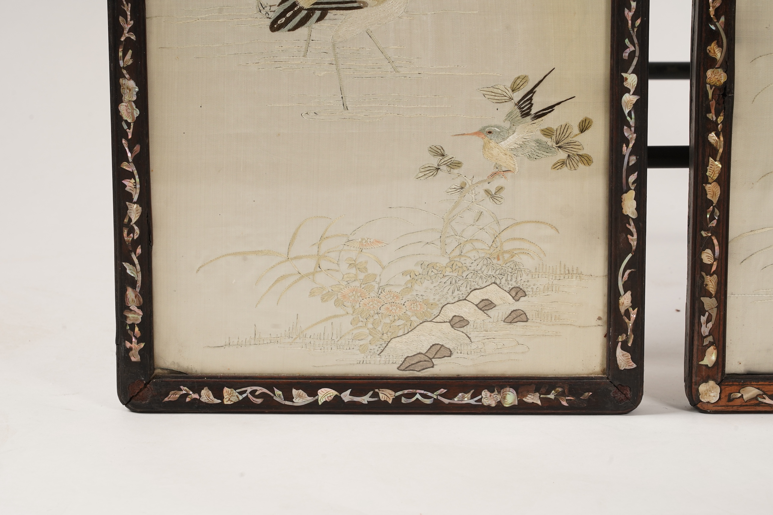 A pair of Chinese embroidered silk ‘bird’ panels, in mother-of-pearl inlaid hongmu frames, late 19th/early 20th century